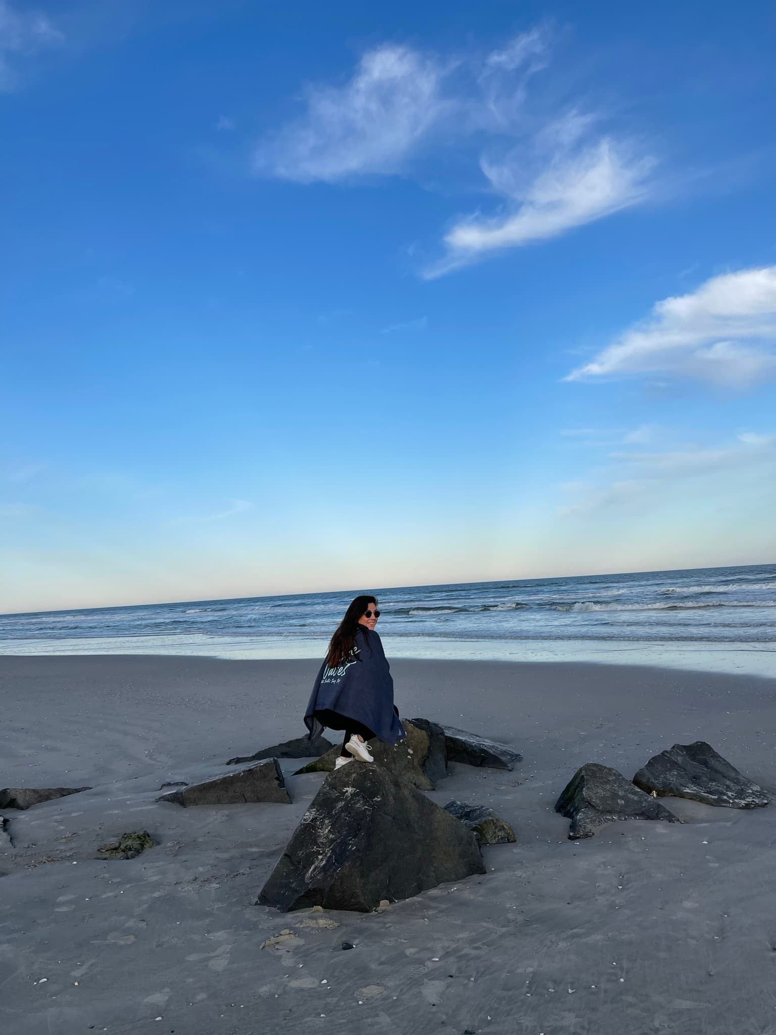 Picture of Carolyn siiting on rock on beach