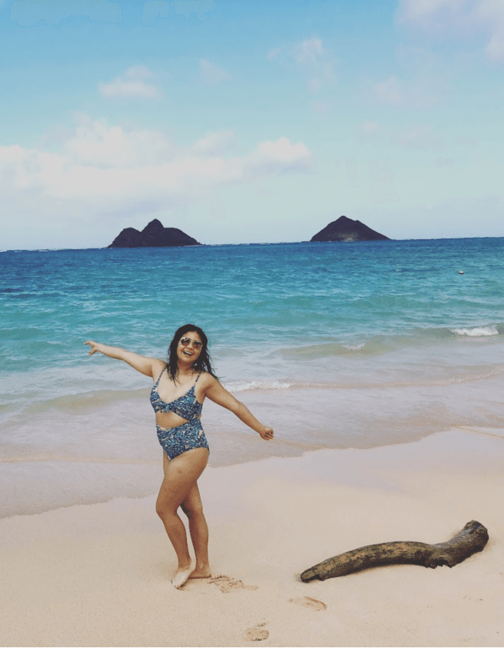 Claudine on a beach with a beautiful view.
