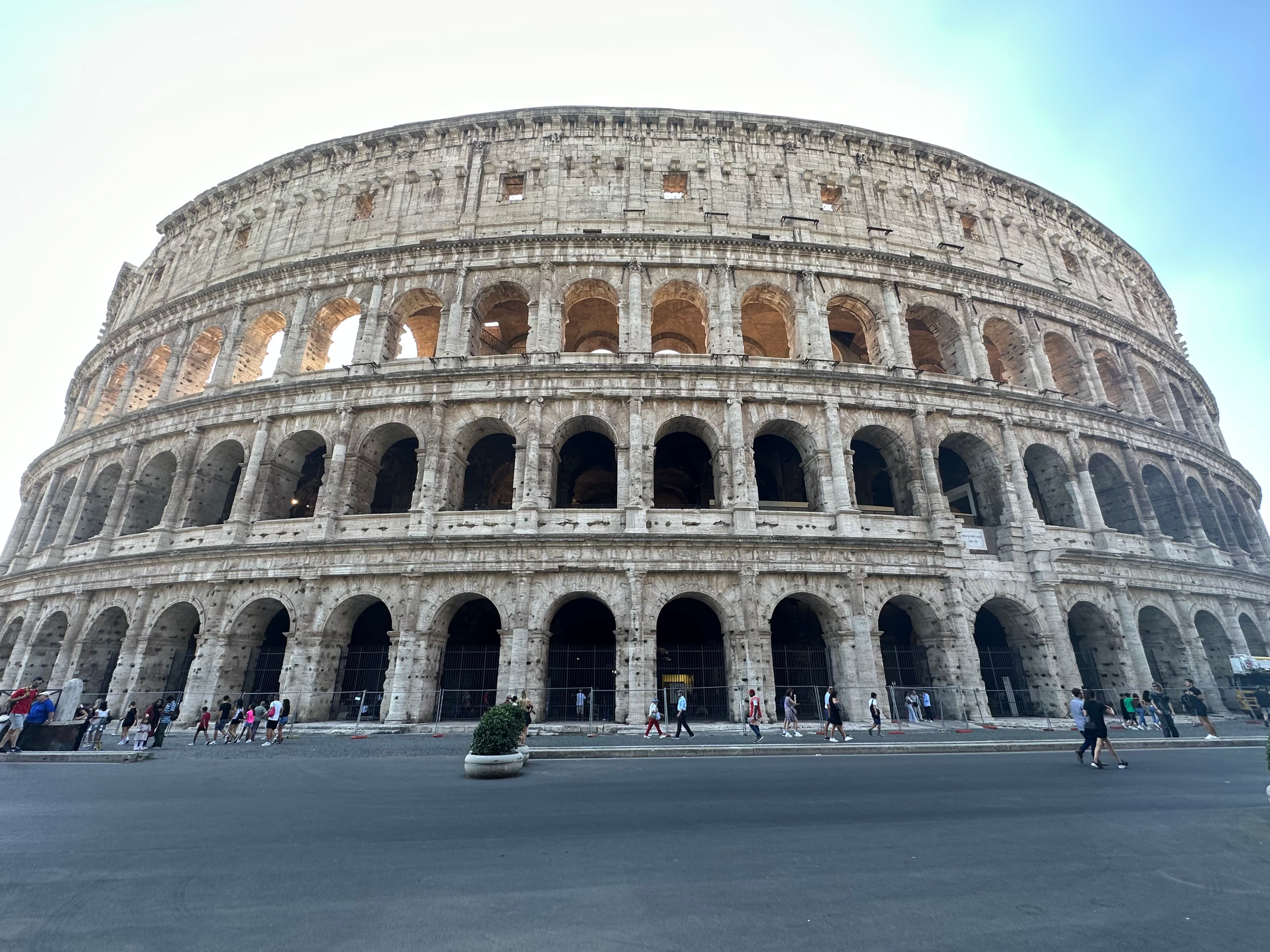 A large coliseum during the day with clear skies and the sun shining.