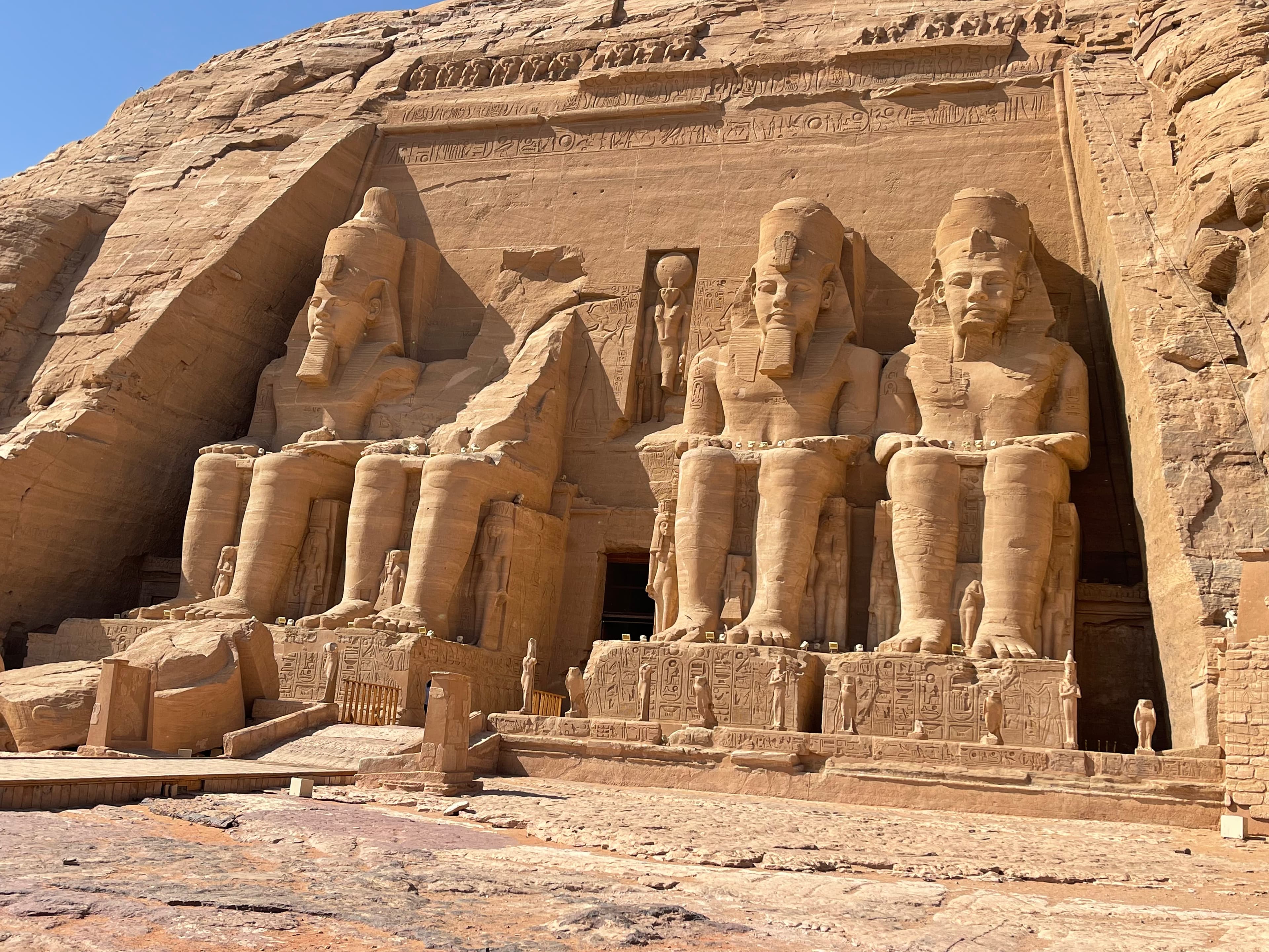 Ancient ruins with statues of Pharos sitting on thrones at the pyramids.