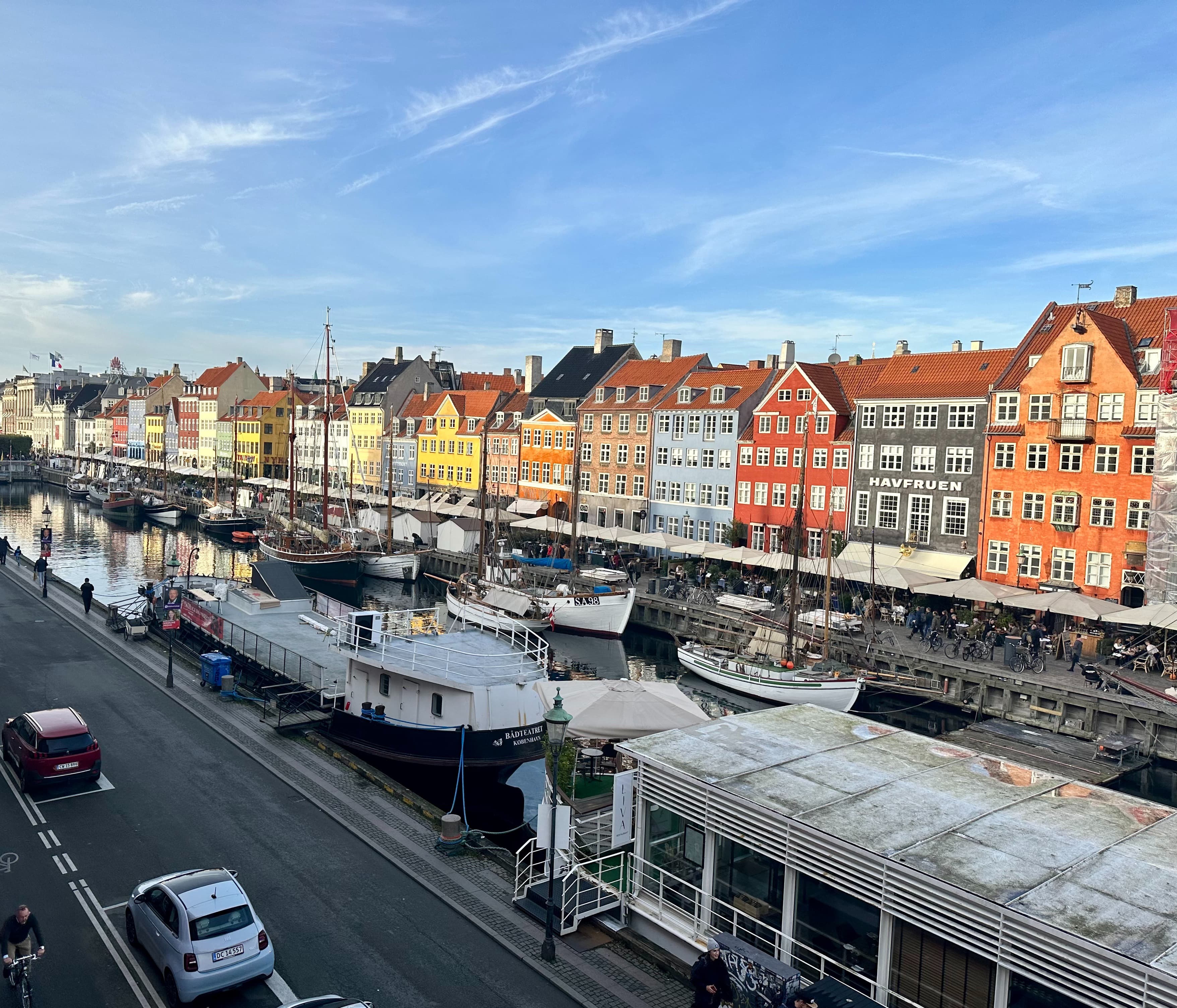 A view of a canal with colorful buildings and boats docked on the edges of the waterway.