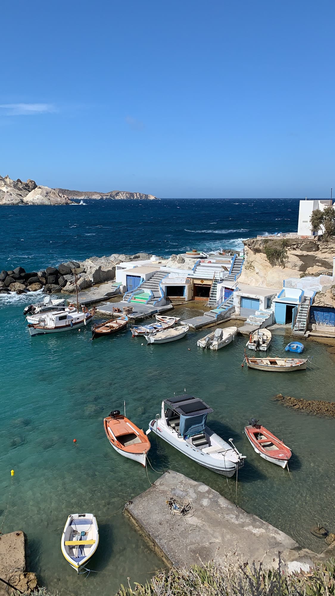 A lovely boat dock with fishing boats and the ocean in the distance.