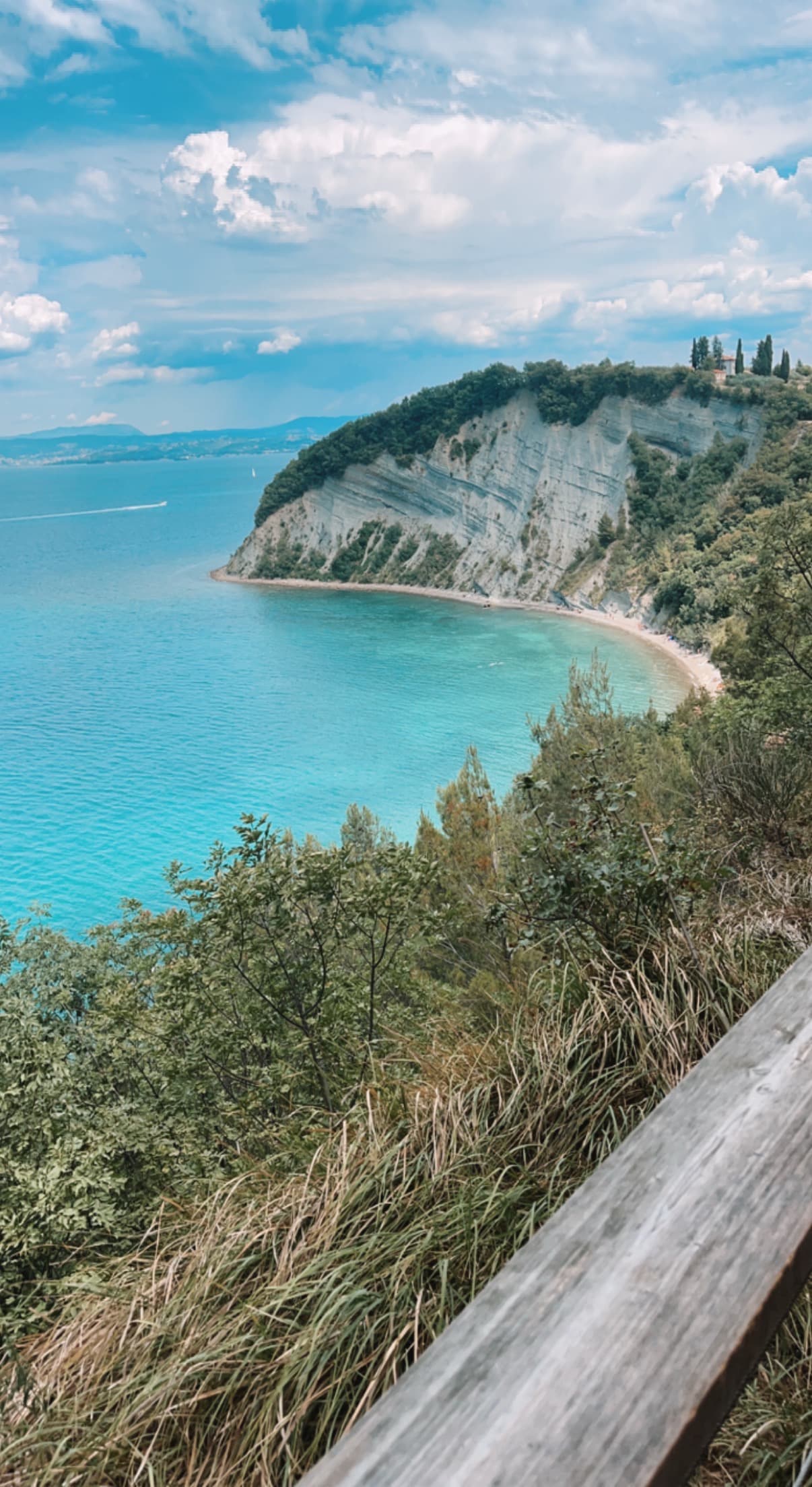 View of a curved coastline with blue water and sky