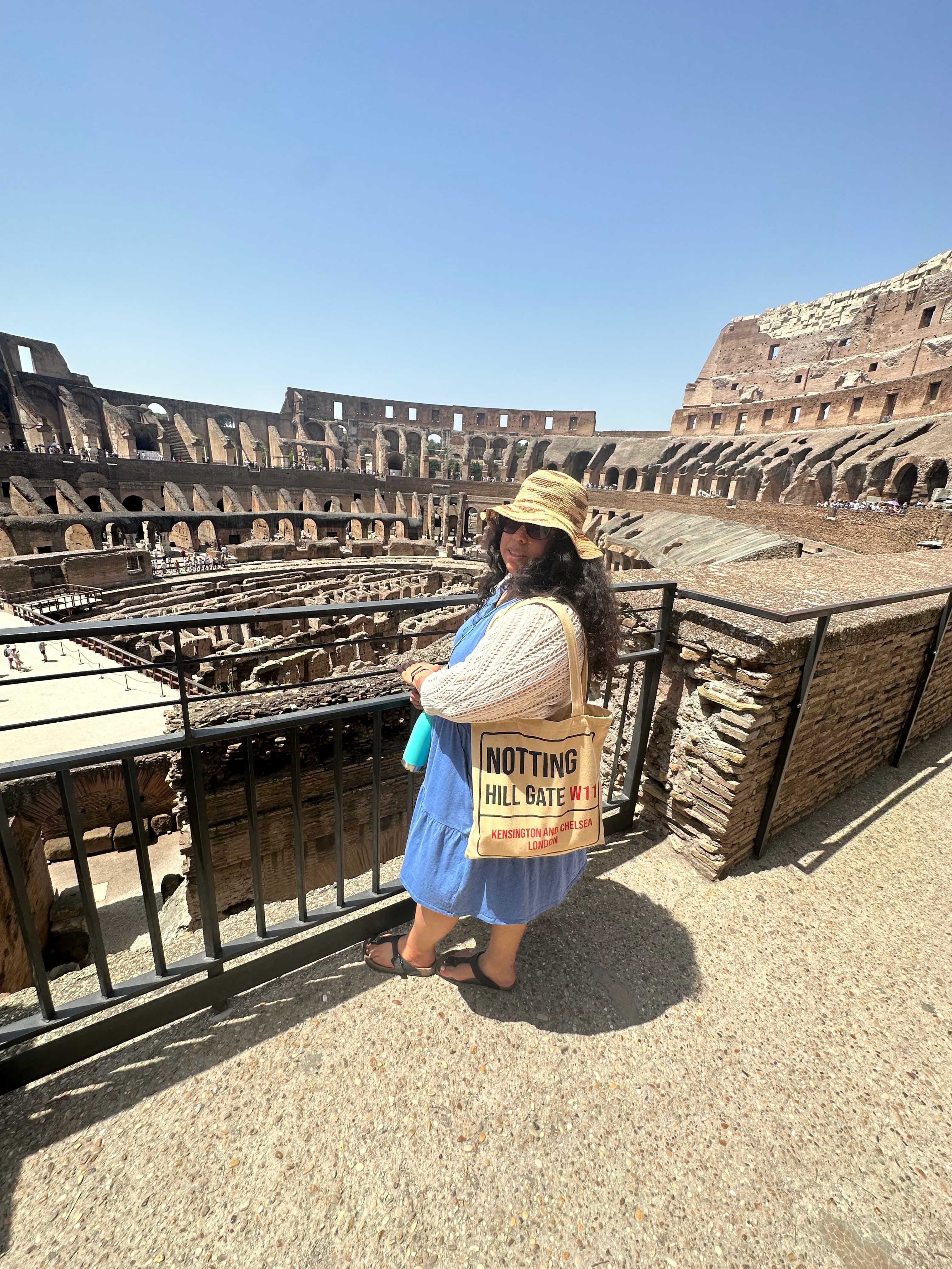 Michelle in a blue dress and straw hat at the Colosseum