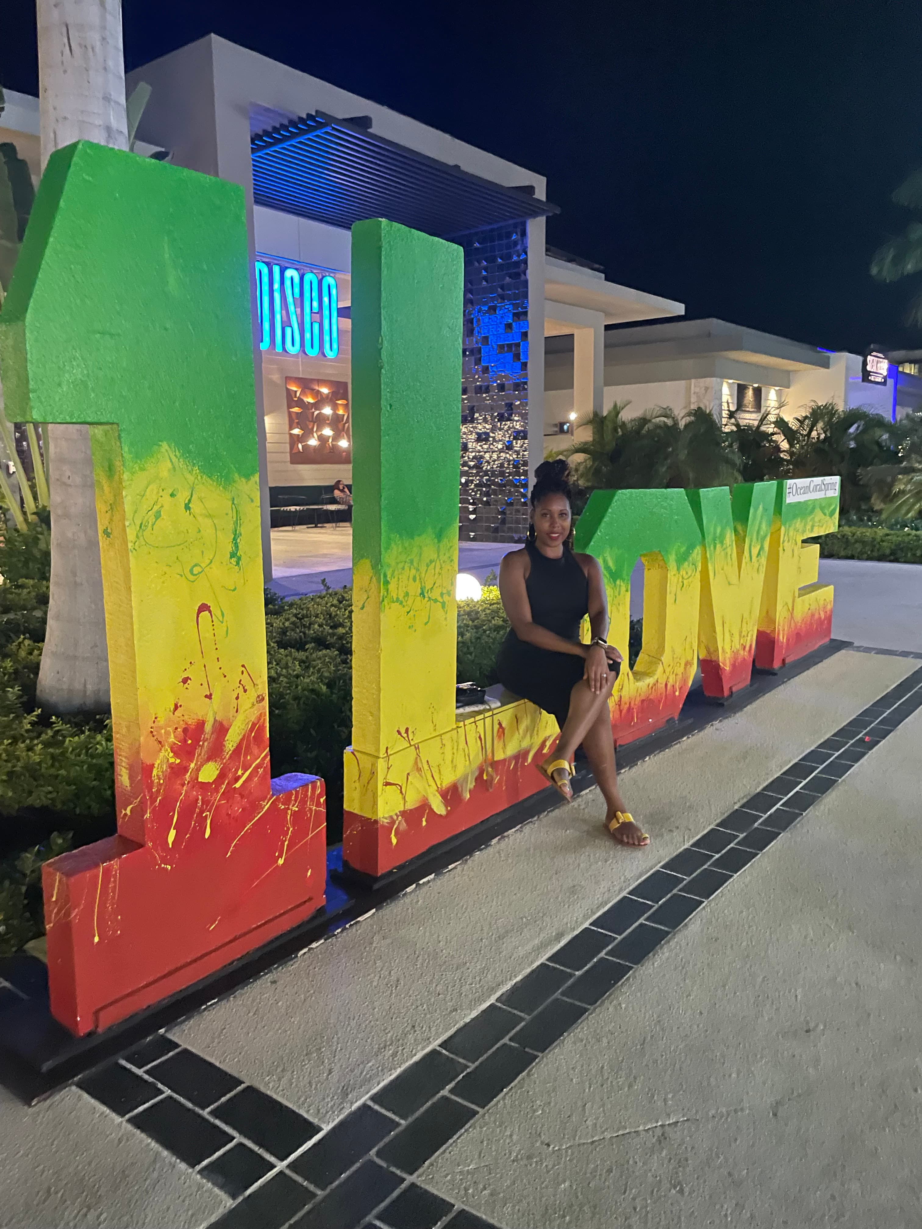 Picture of Lynnett sitting on Love sign