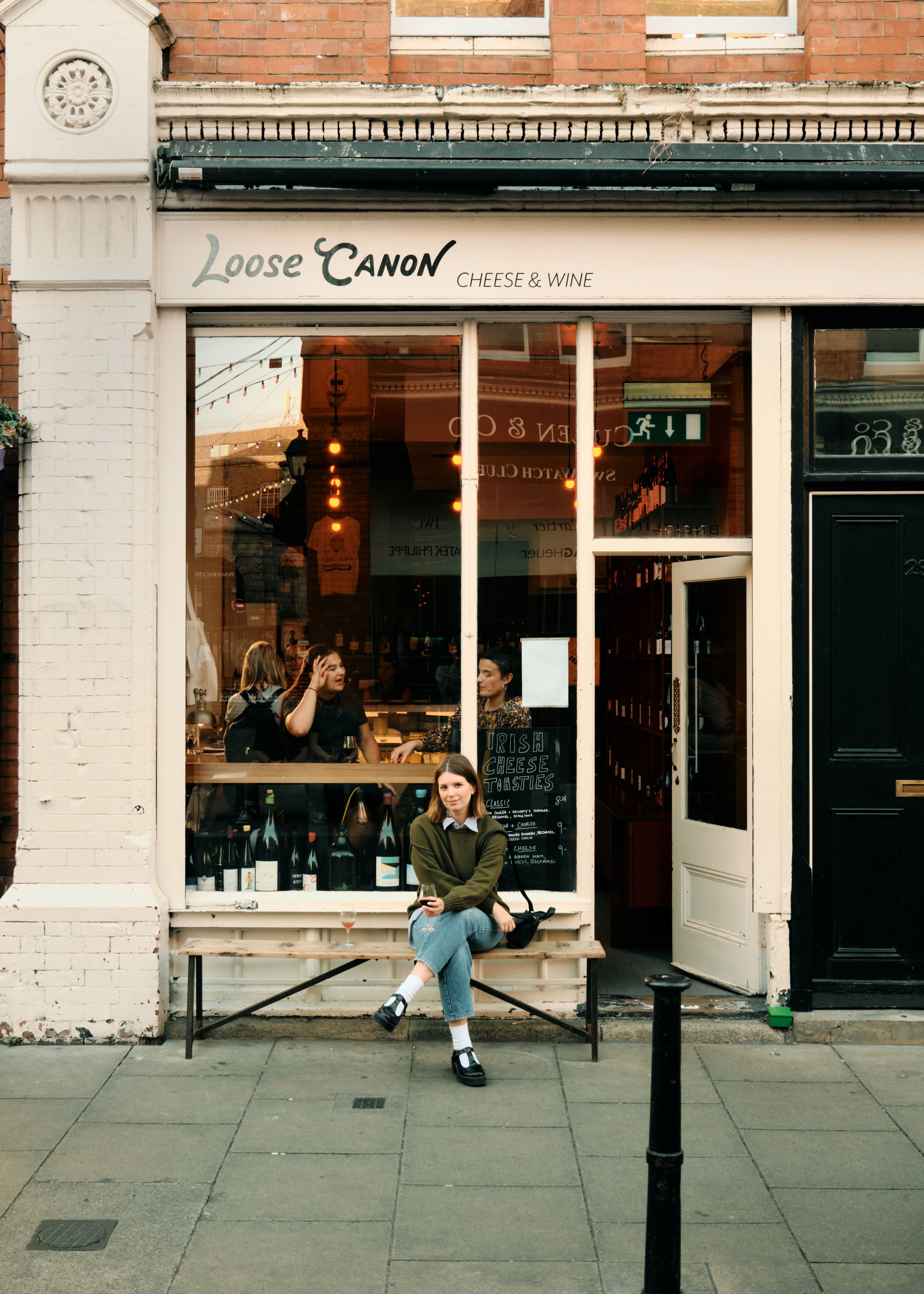 Picture of Hannah sitting on bench outside Loose Canon Cheese and Wine