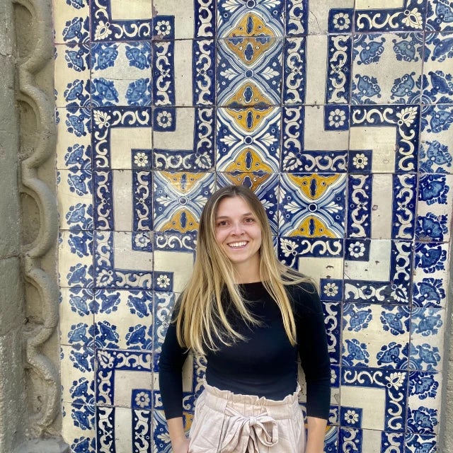Travel Advisor McKenley Stewart posing with a mosaic wall behind her. 