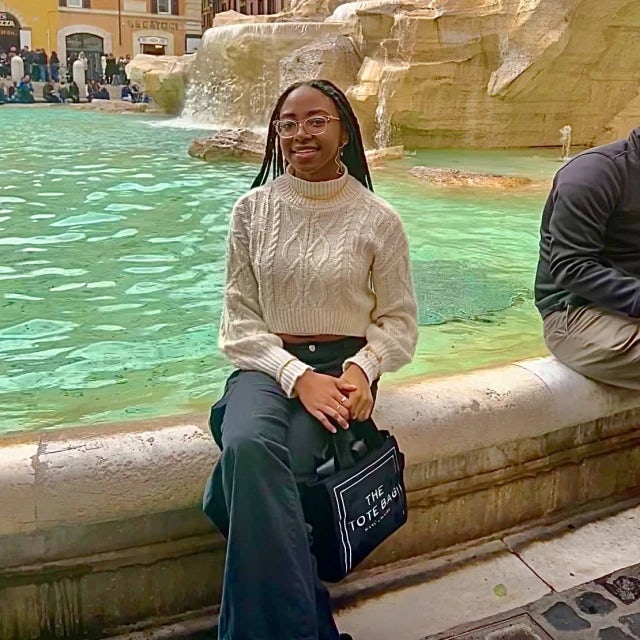 Travel Advisor Jaliah Spearman sits on a European-style fountain. 