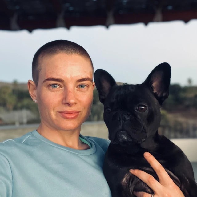 Travel Advisor Jessie Voss in a blue sweatshirt holding a black dog.