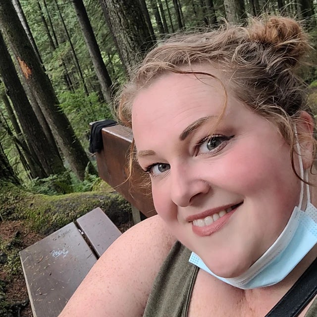 Travel Advisor Kymberly Forest on a park bench in the woods.