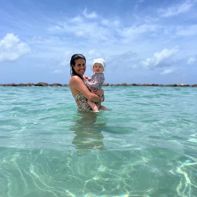 woman holding a baby in turquoise water