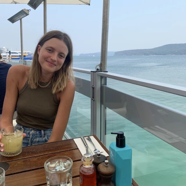 Caneel Lange-Blom Travel Agent sitting with drink at oceanfront restaurant