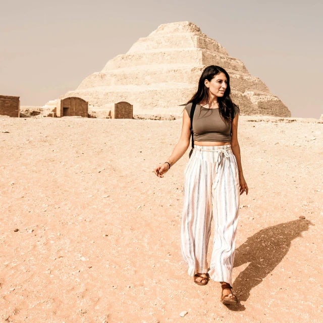 Jessica Pena Travel Agent wearing striped pants standing in front of pyramid