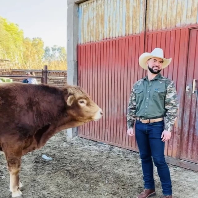 Travel advisor Christopher Anderson in cowboy hat next to a cow