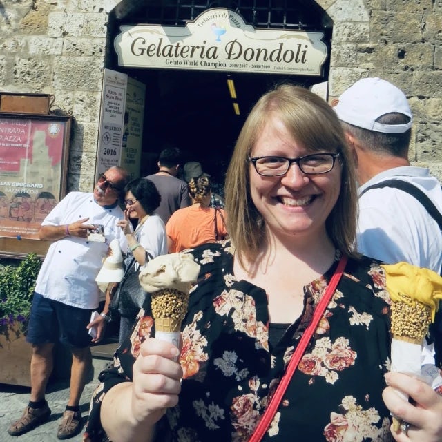 Travel advisor Staci Kirk with glasses and short blonde hair holding two ice cream cones