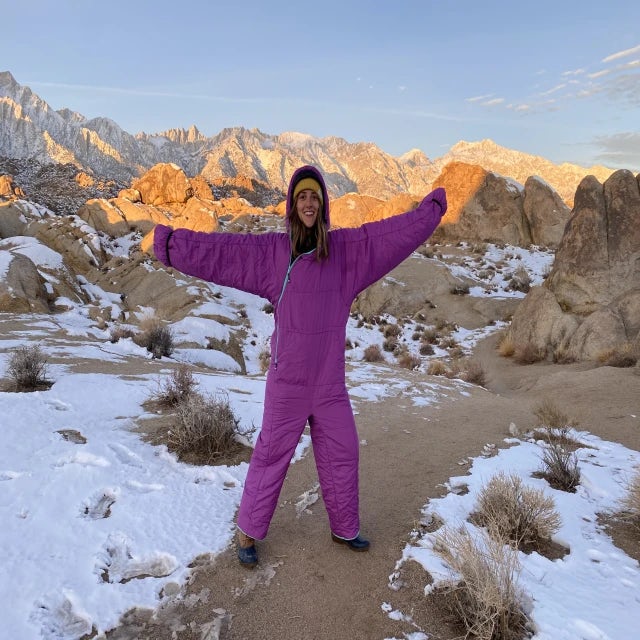 woman wearing purple suit with mountains in the background during sunrise