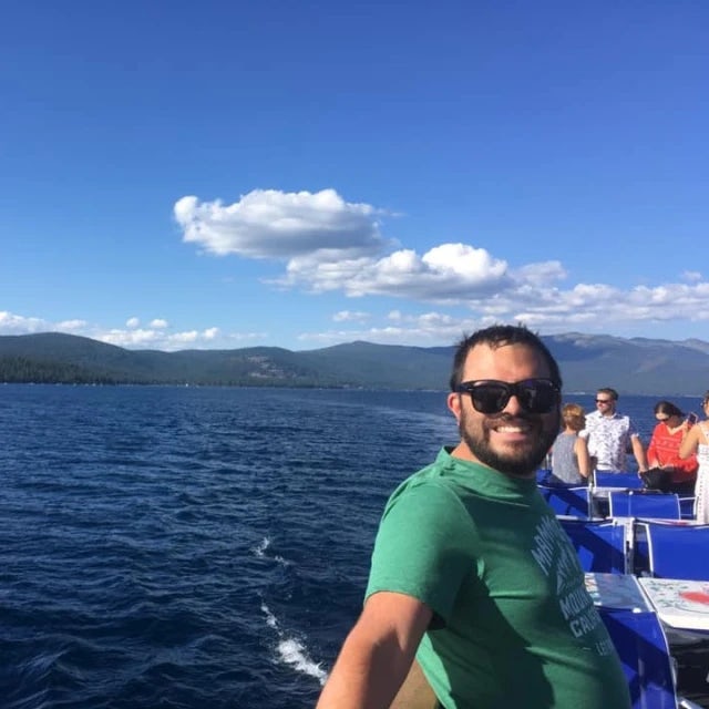 Travel Advisor Edgar Roy in a green shirt on the water with mountains in the background.