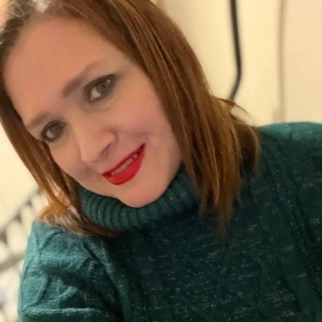 Travel Advisor Sandy Carino in a green sweater and red lipstick.