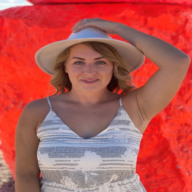 Fora travel agent Ashley Barbic wearing white hat with red background