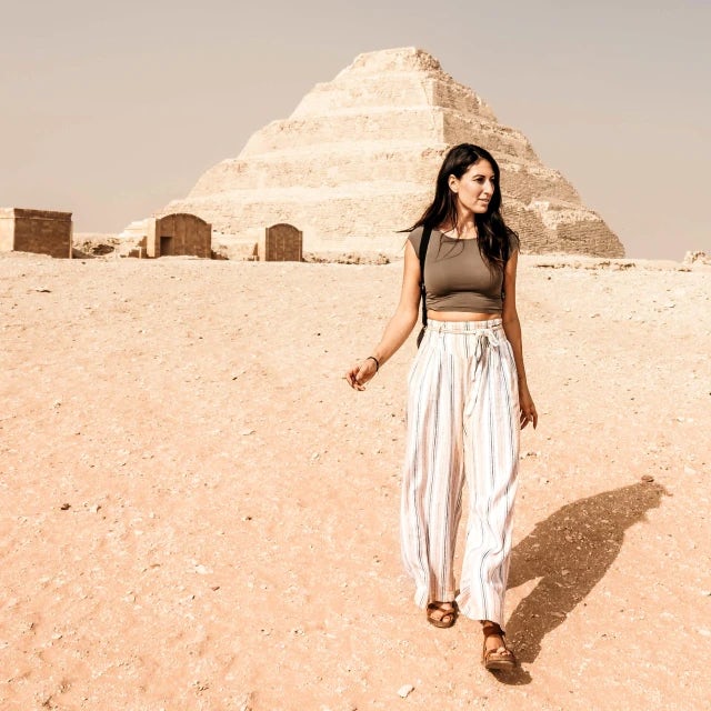 Jessica Pena Travel Agent wearing striped pants standing in front of pyramid