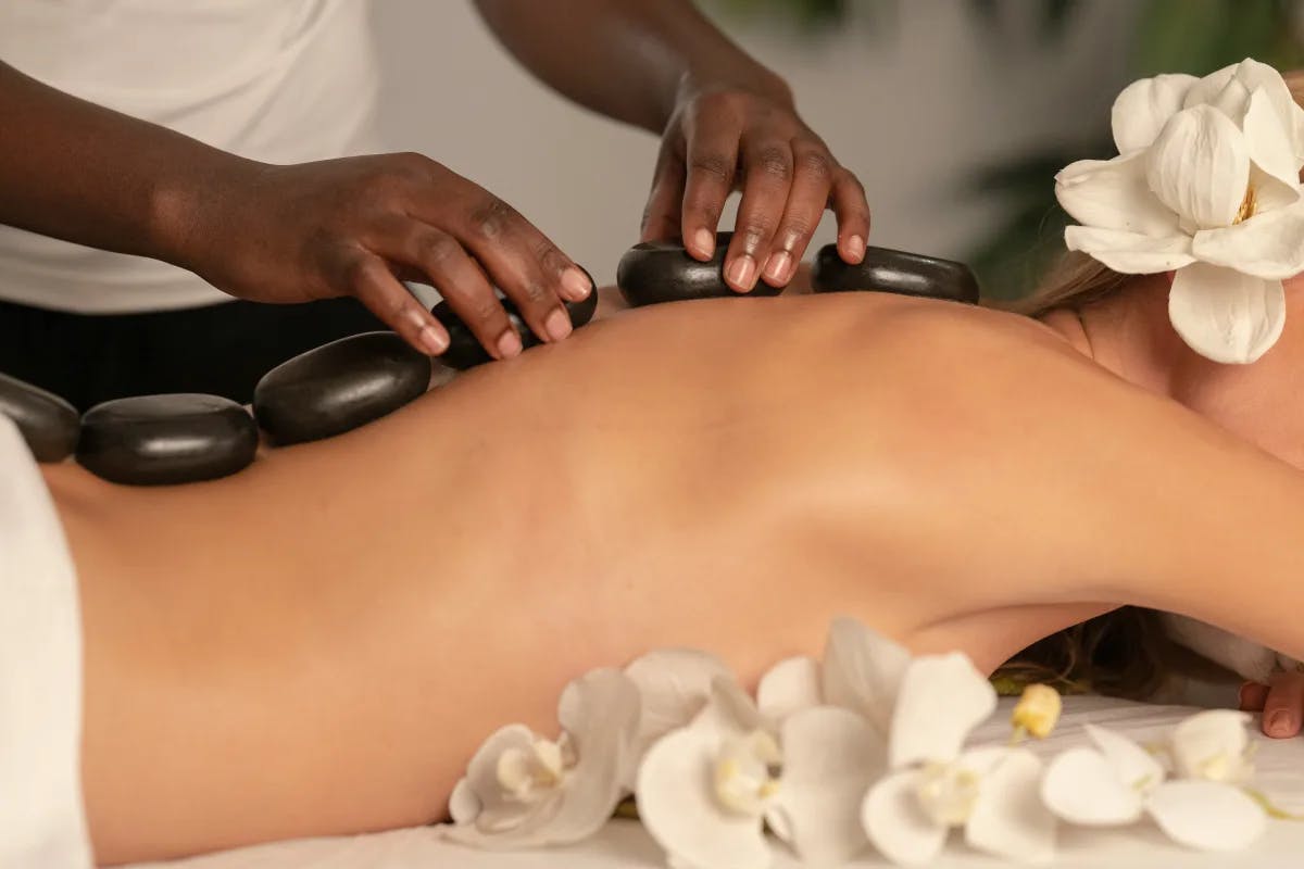 A picture of a person giving a hot stone massage at the spa.