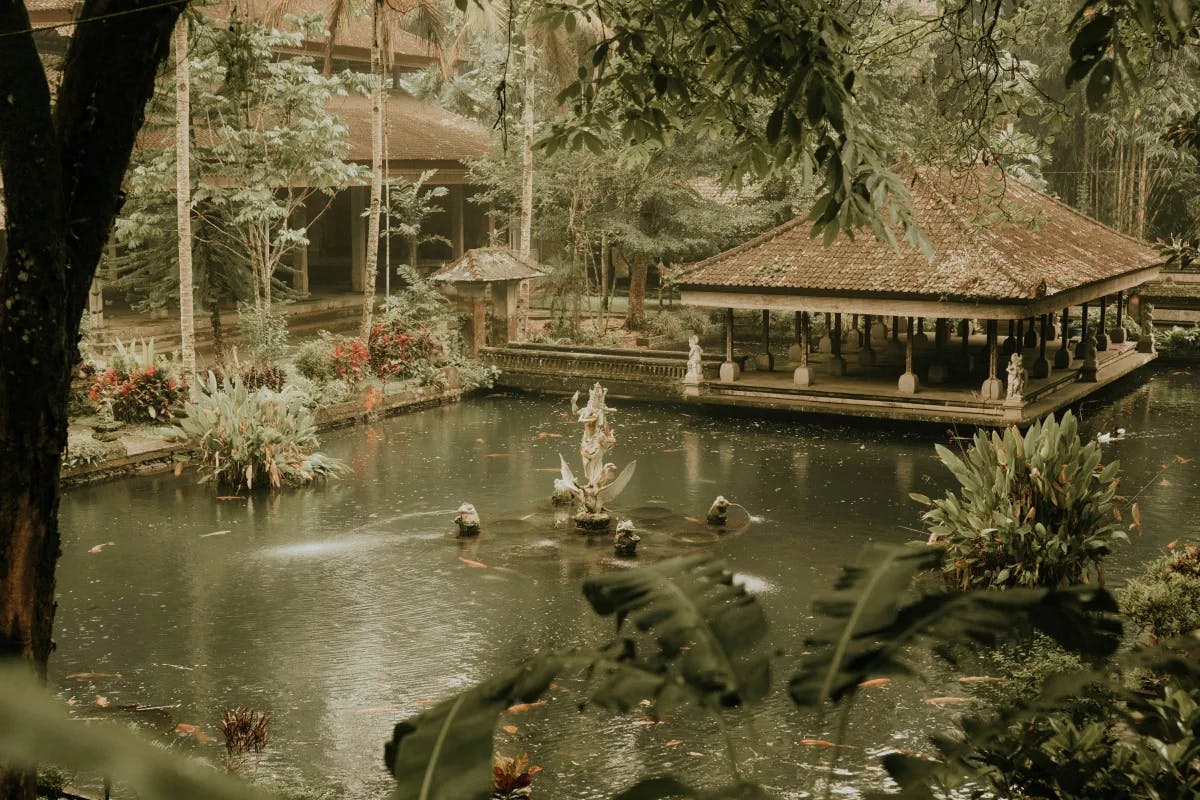 A picture of a pond surrounded by trees and a gazebo