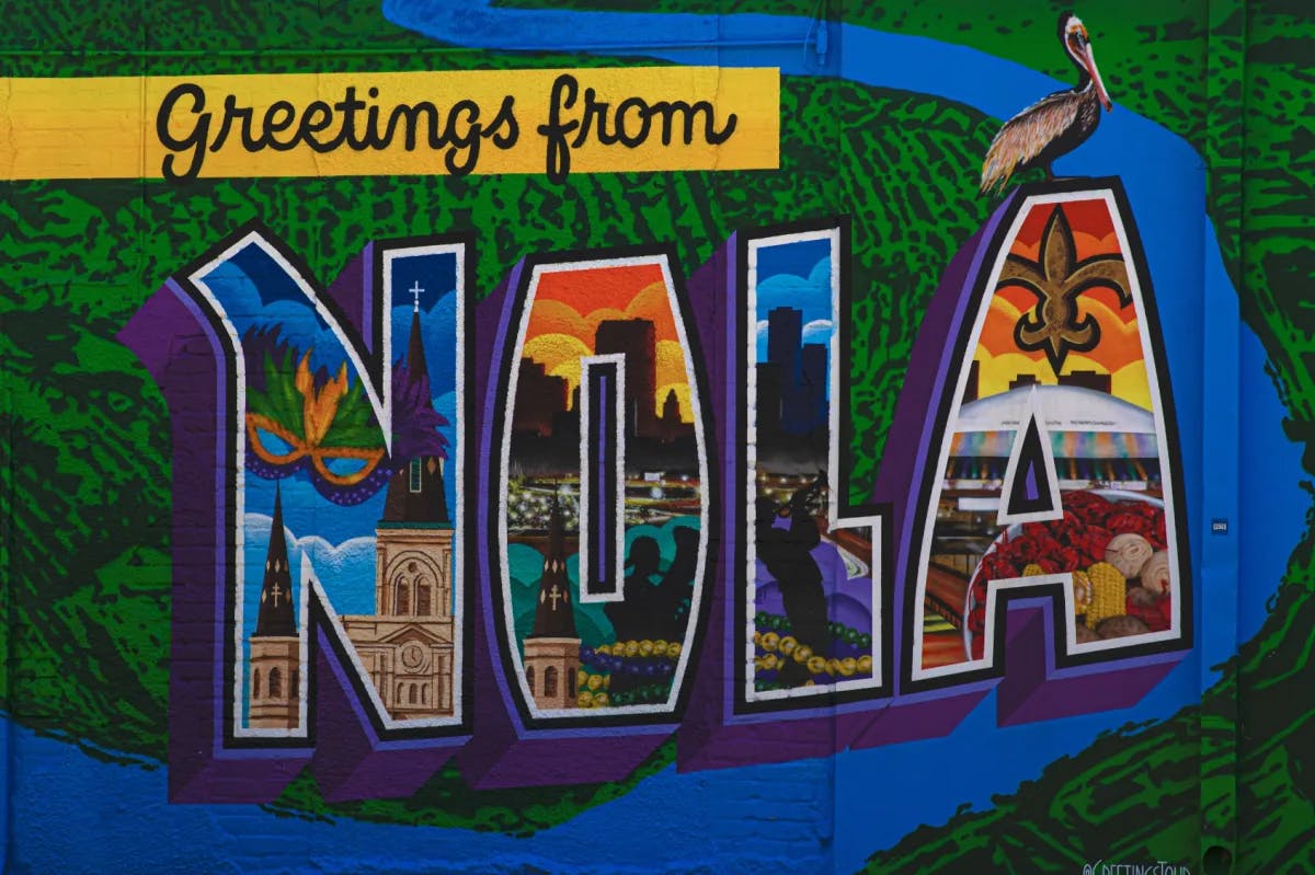 A colorful greetings from Nola street mural with various pictures depicted on a color scheme of yellow, green, blue, purple, orange and red. 
