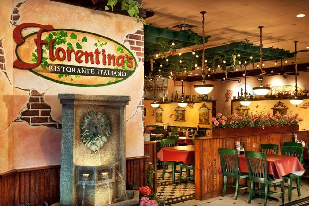 The interior of Florentina's Ristorante Italiano, made to look like a traditional Italian restaurant with red tablecloths, black and white checkered floors and brick wallpaper.