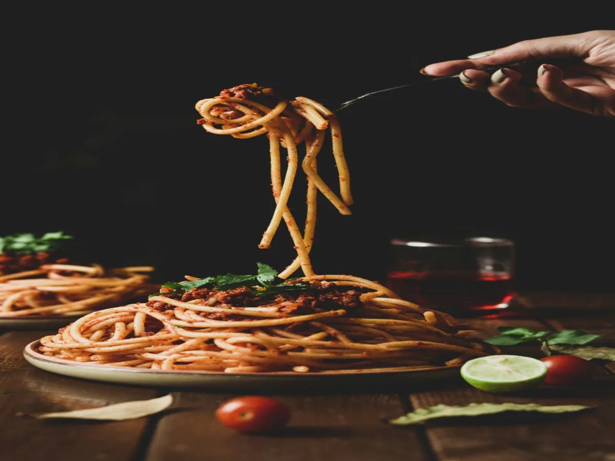 A picture of a person holding a pasta with a fork.