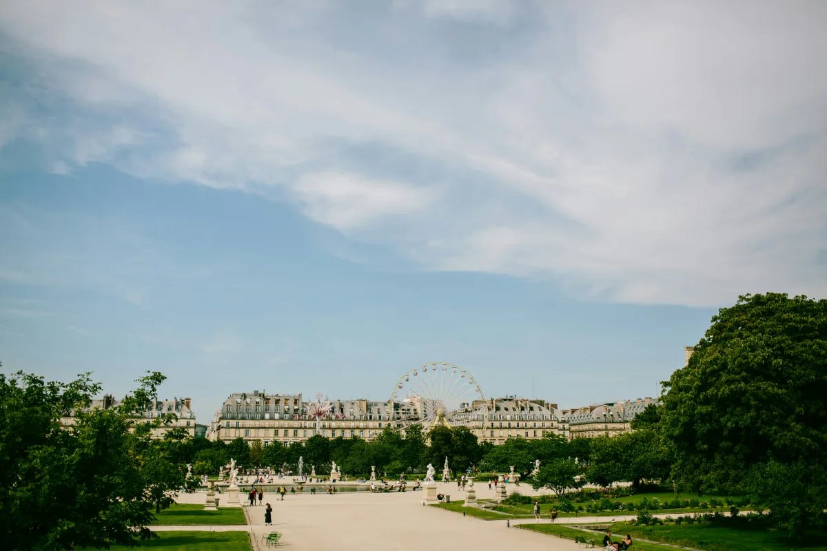 A far view of the Tuileries Garden with a ferris wheel and trees on either side.