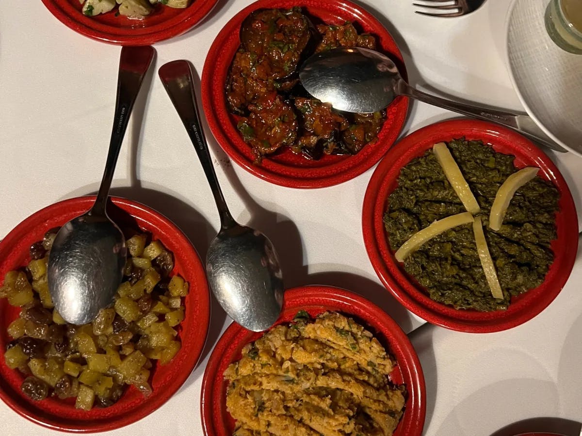 A variety of Moroccan dishes in little red bowls.
