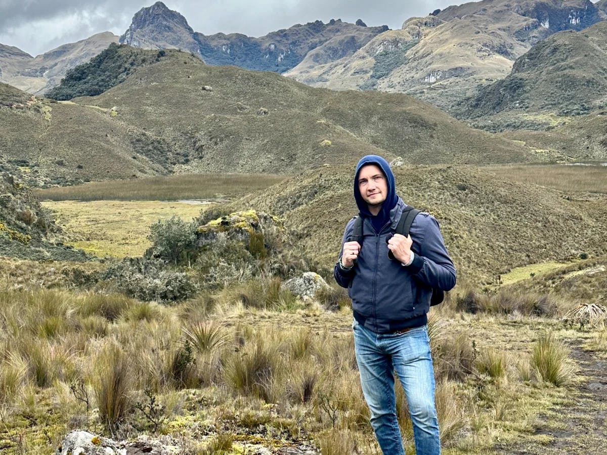 A man with hoodie and backpack hiking.