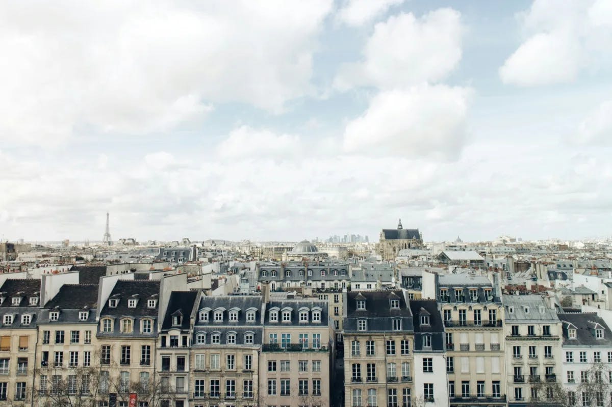 A view of the rooftops and architecture of Paris, France with various windows and neutral color scheme. 