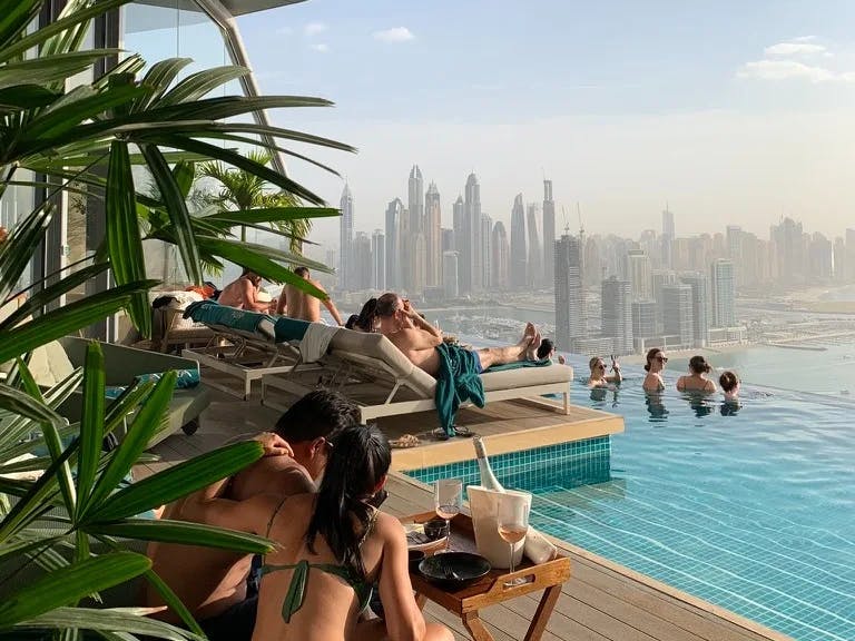 People in pool with city buildings in background.