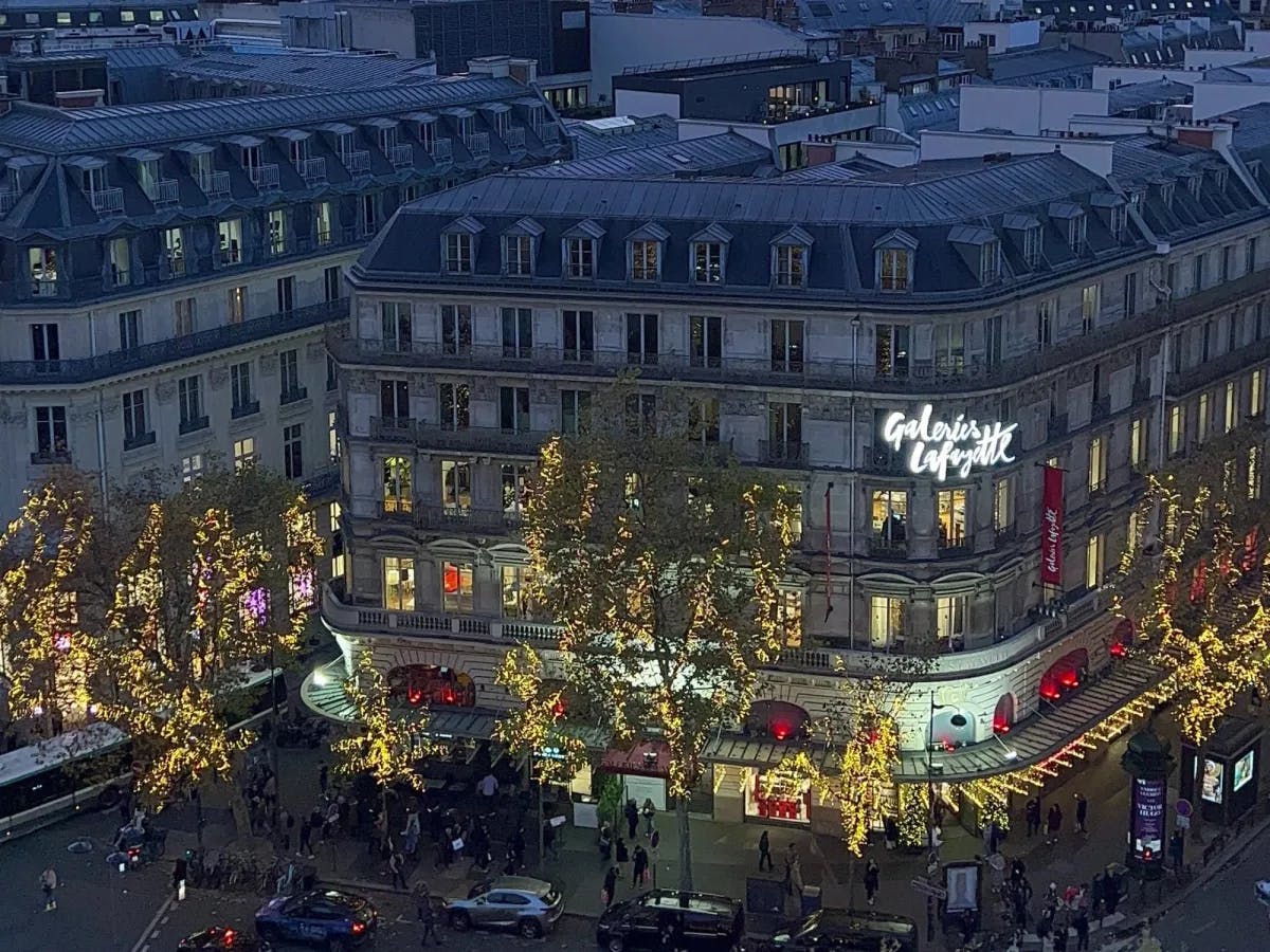 The Galeries Lafayette, tall buildings surrounded by decorated trees with lights, on day 2 of a Paris 4–day itinerary.