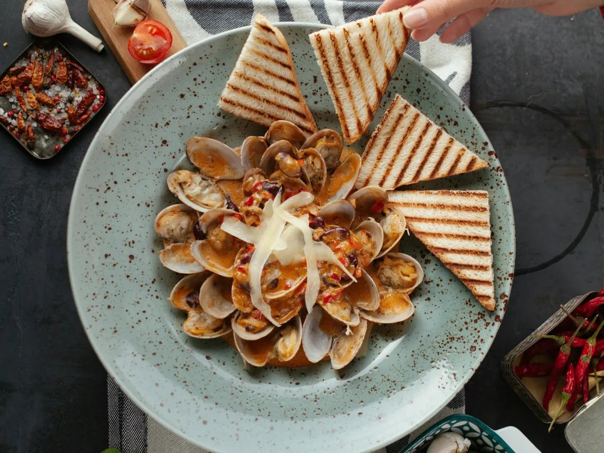 Toasted bread with clams on a plate.