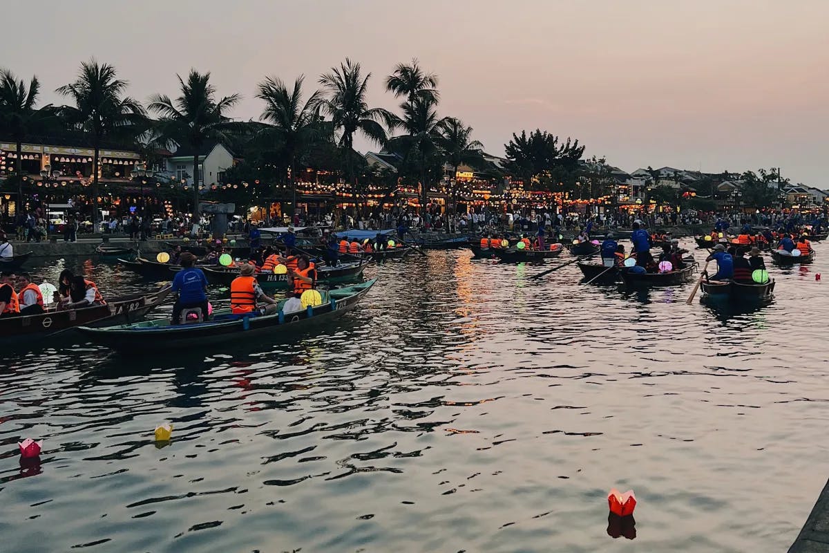 A view of Thu Bồn River, a scenic waterway in Hoi An, with many small boats and people