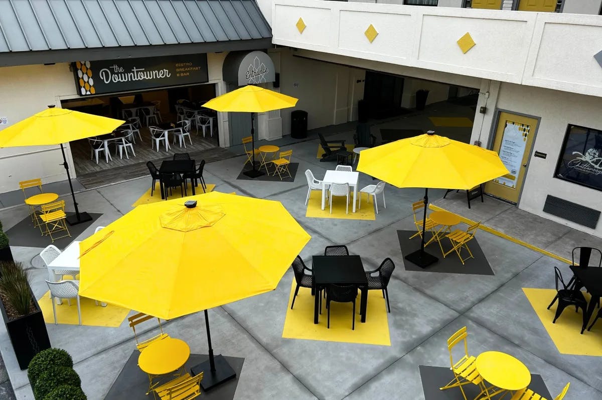 An outdoor dining area with bright yellow umbrellas during the daytime