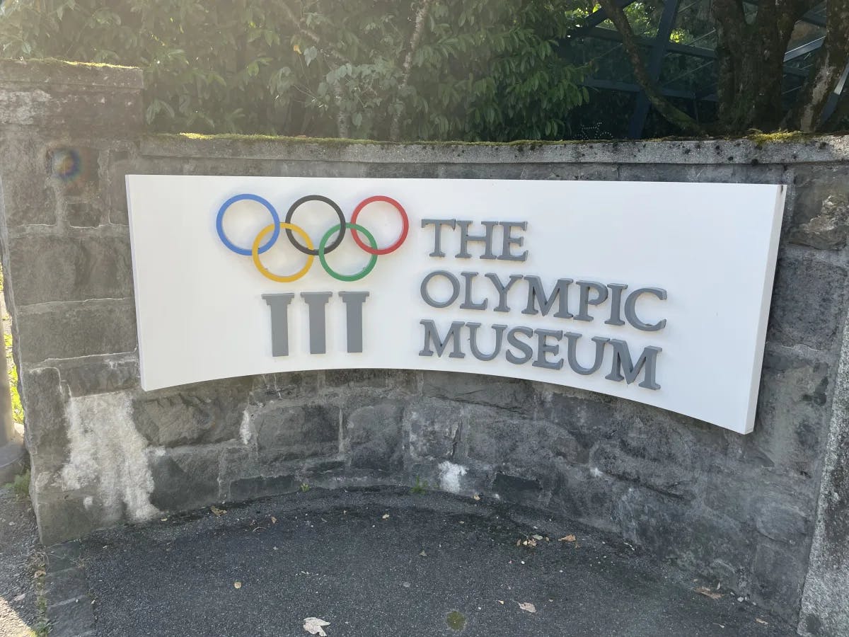 A view of "The Olympic Museum" sign on a stone facade. 