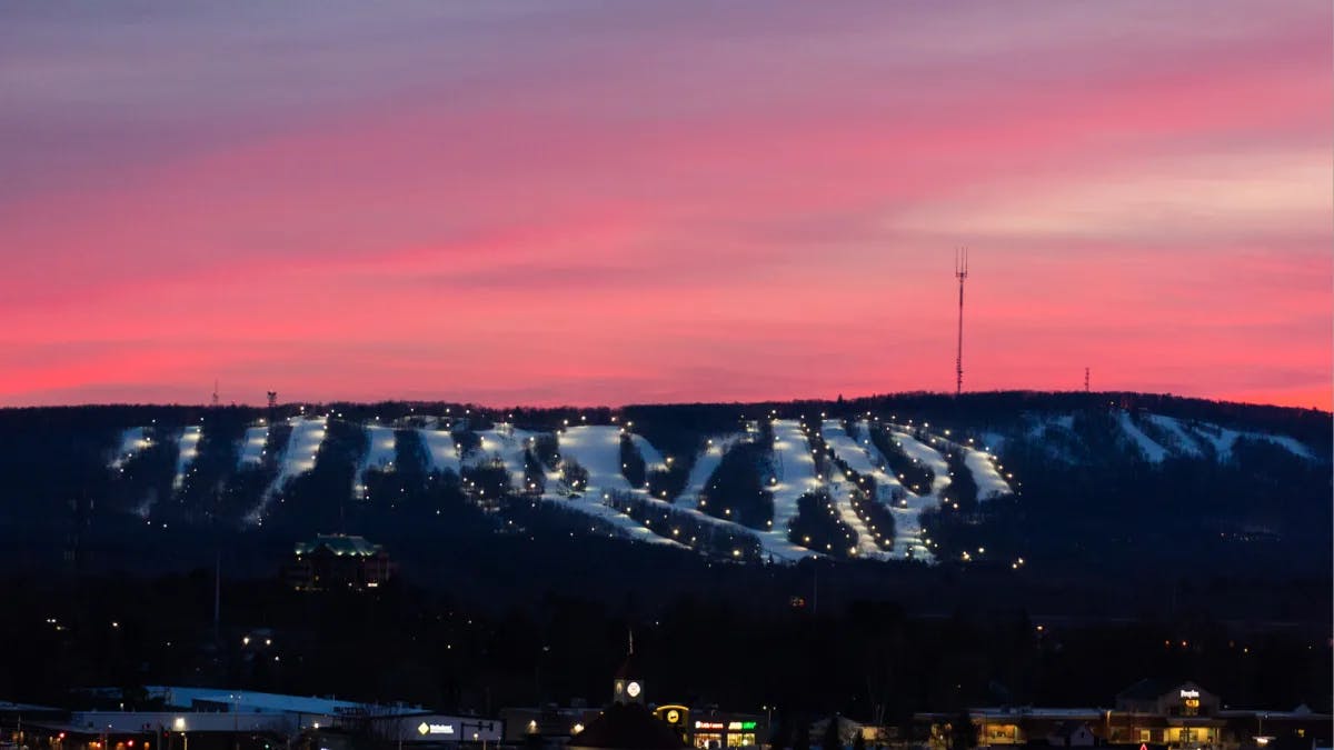 A view of a lit up mountain during the sunset