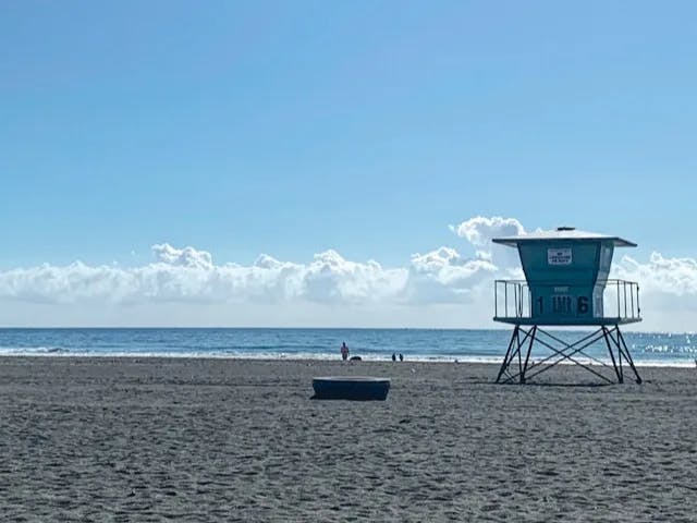 a lifeguard tower on a beach with a boat in the water 