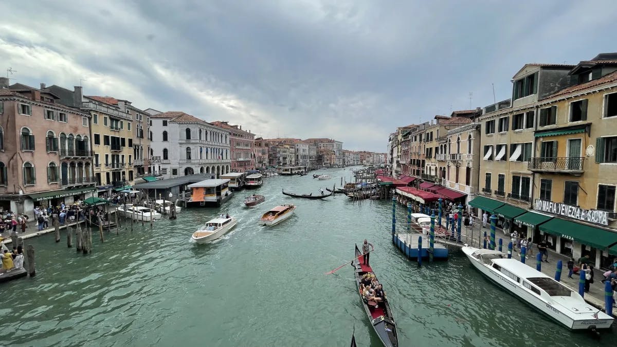 A view of the Venice canal with boats and colorful old buildings. 