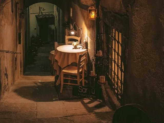 A dining table in a dimly-lit alley way