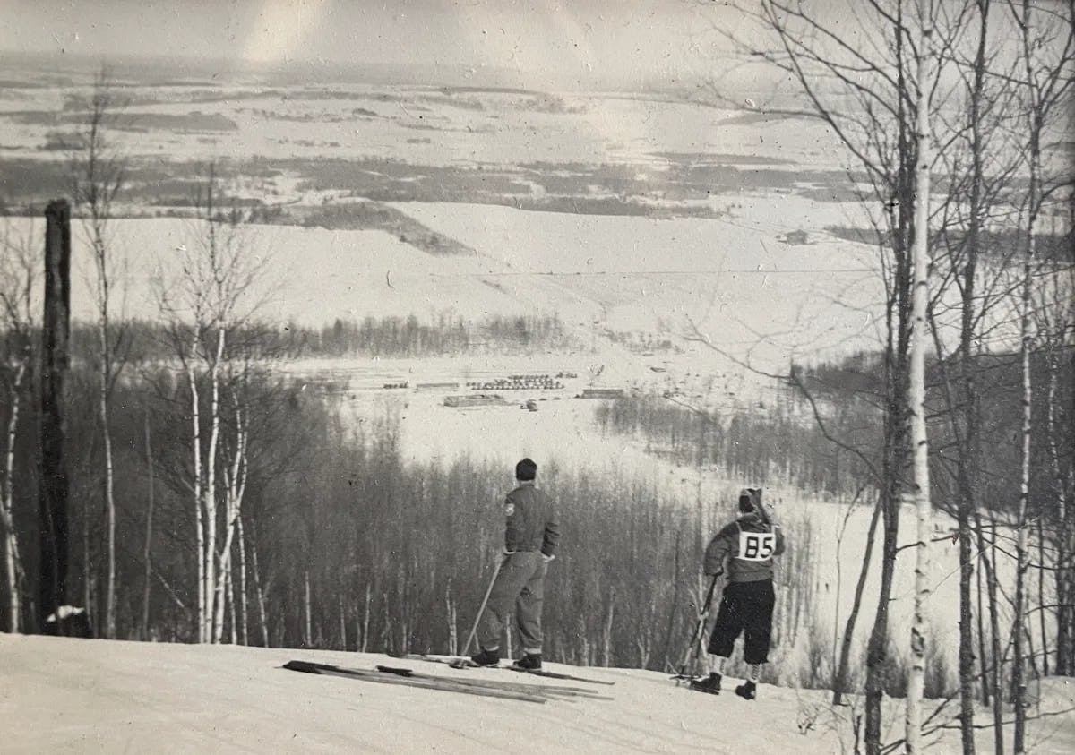 A vintage, black and white photo of skiers on a snow-covered mountain