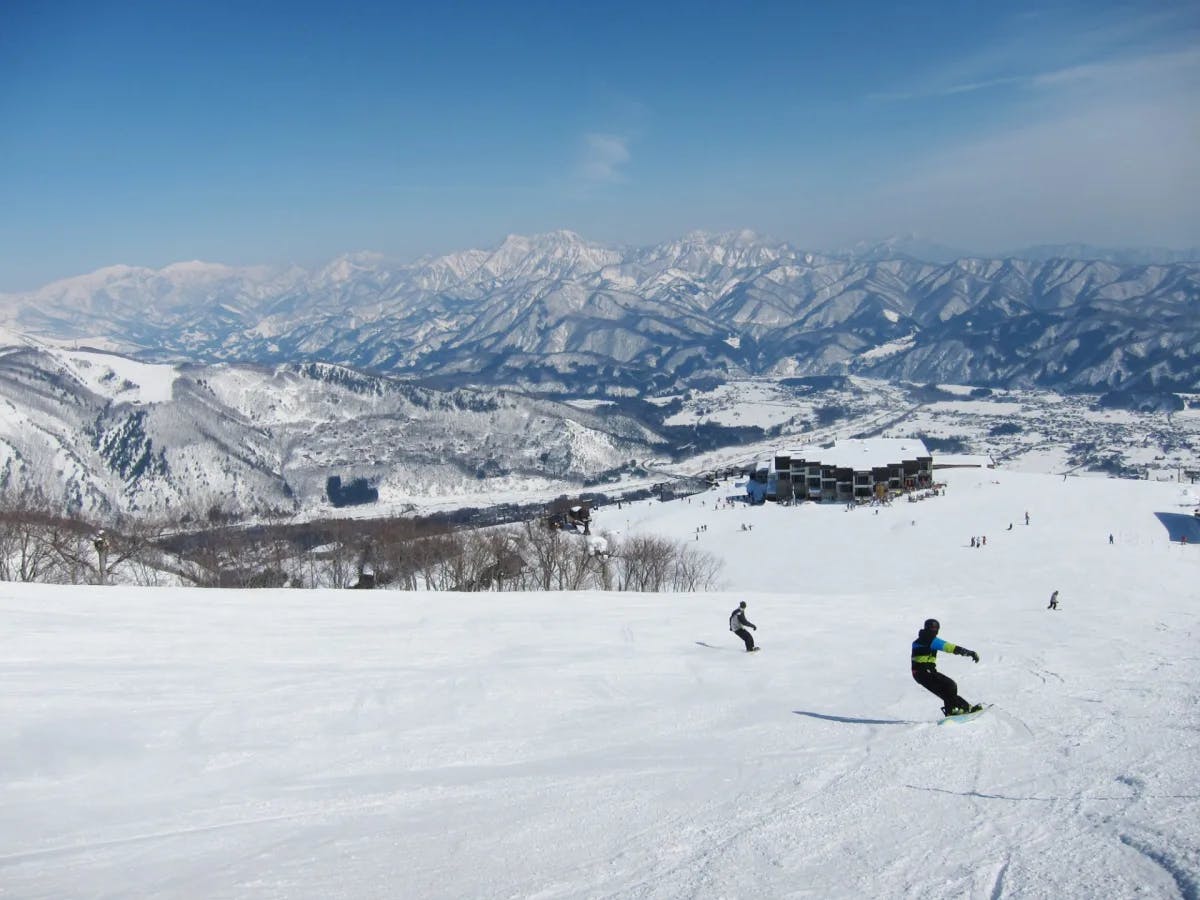 People skiing in Hakuba, Japan with mountains in view