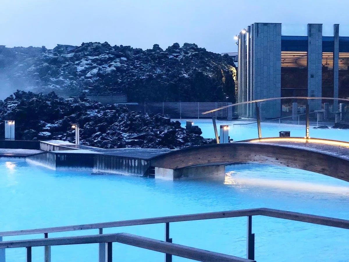 A relaxing iconic geothermal spa with a bridge and rocky landscape