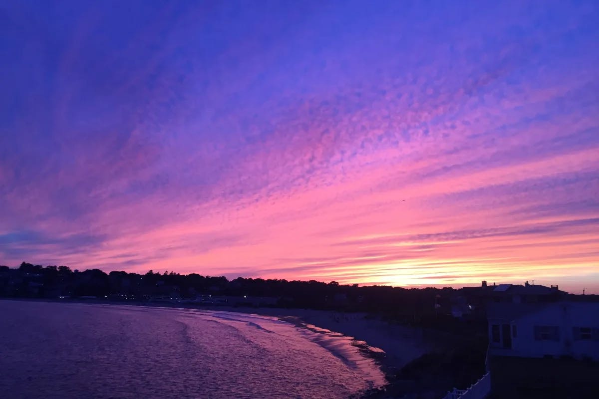 A stunning coastal sunset with the sky ablaze in shades of purple and pink.