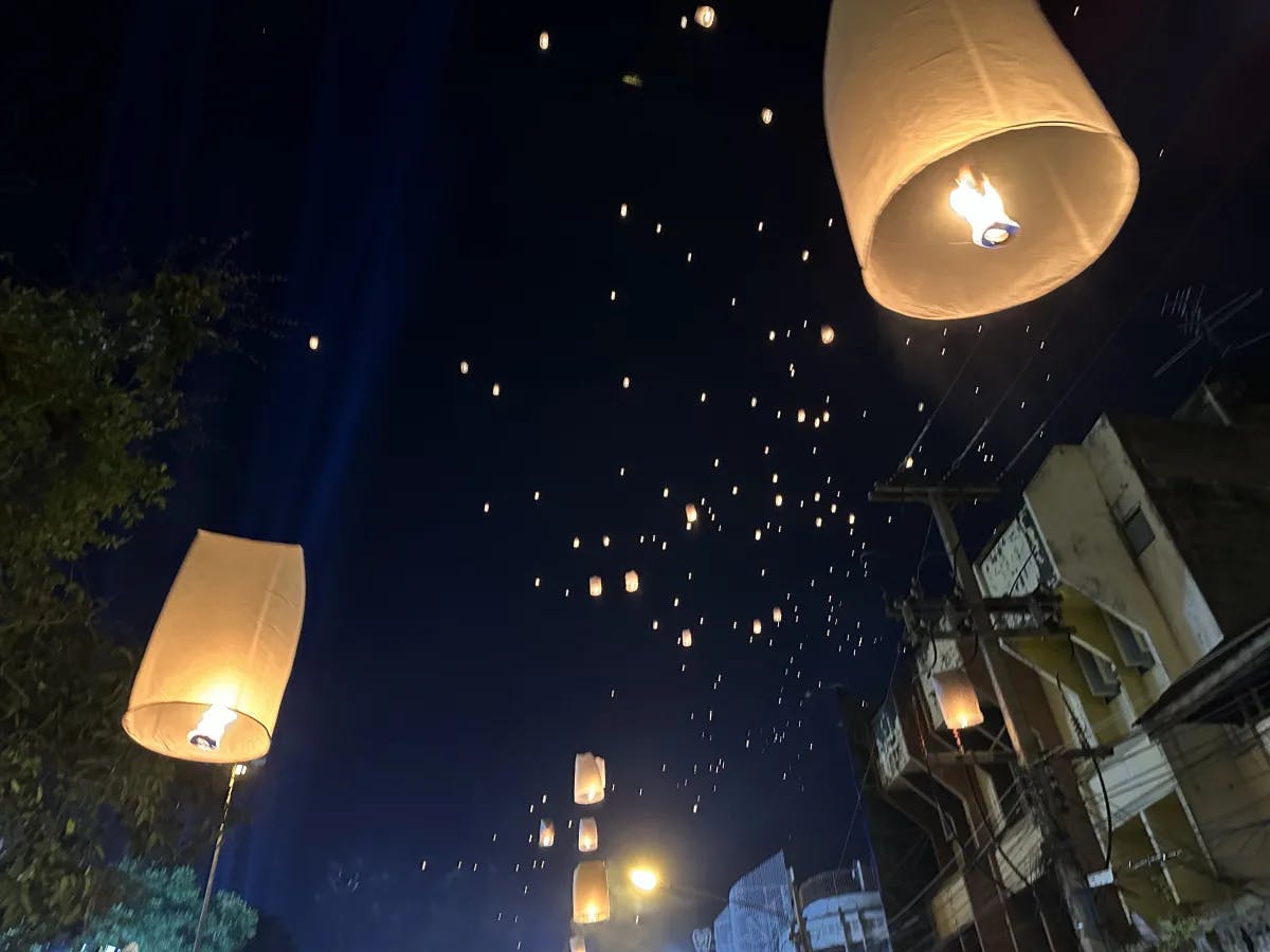 A bottom-up view of lanterns floating throughout the night sky.