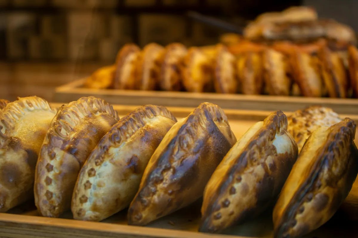 A row of empanadas in a bakery.