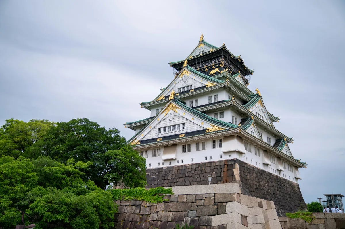 A low-angled picture of Osaka Castle during the daytime.